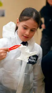 School child wearing a forensic suit holding evidence
