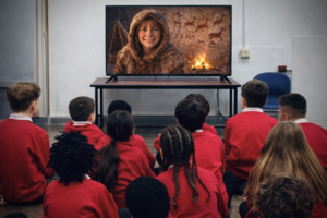 stone age character on screen with children